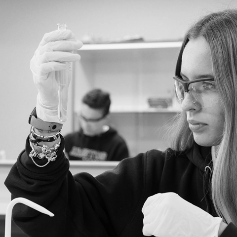 Alumna en laboratrio con una probeta